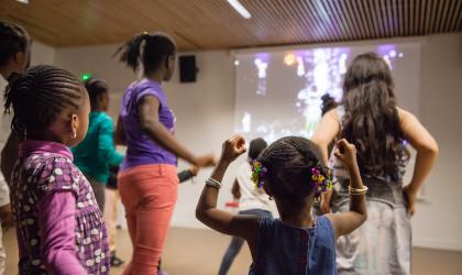 Accéder à l'événement" Jeu vidéo : Just Dance". Visuel : Des enfants debouts devant un écran, s'apprêtant à suivre une chorégraphie.