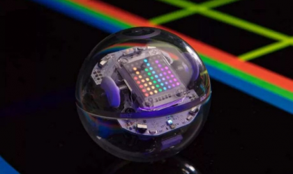 Accéder à l'événement "Atelier Sphero Bolt : Défi labyrinthe". Visuel : Un robot sphérique bardé de voyants coloré. En arrière plan on peut voir un fond noir et des bandes de couleur bleue, verte et rouge.