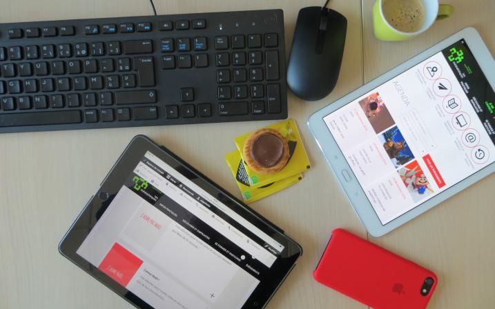 Accéder à l'événement "Découverte des services numériques de la médiathèque". Visuel : Un bureau sur lequel sont posés divers éléments : deux tablettes, un smartphone, un clavier de PC, une souris, une tasse de café et un biscuit."